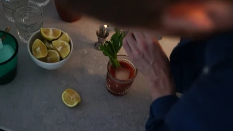 Close-up handheld shot of man grinding pepper on the drink Stock Footage 114884578