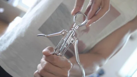 Close-up handheld shot of man opening wine bottle with corkscrew Stock Footage 115060270