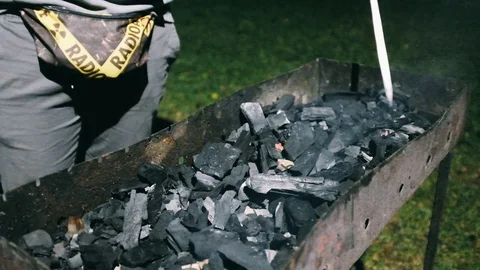 Close-up handheld shot of man preparing barbecue at night Stock Footage 122512908