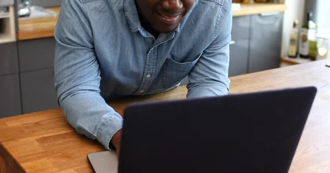 Close-up handheld shot of man using his laptop in kitchen Stock Footage 119758505