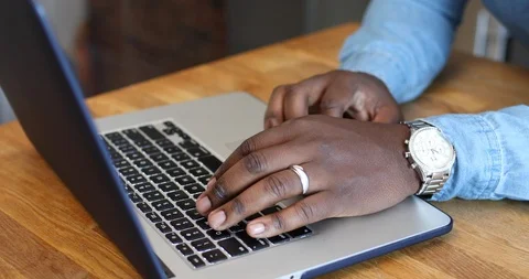 Close-up handheld shot of mans hand typing on laptop over the wooden table Video stock 119766697