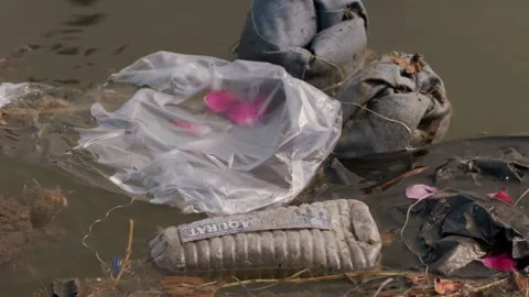 Close up handheld shot of objects discarded on riverbank. High angle Stock Footage 280366584