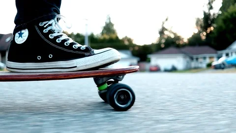 Close-up handheld shot of one boy riding scooter and another boy on skateboard Video stock 114884784