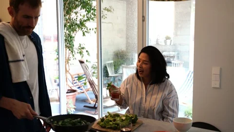 Close-up handheld shot of people talking while preparing food in kitchen Stock Footage 114883340