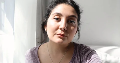 Close-up handheld shot of portrait of young woman looking at camera Stock Footage 120433770