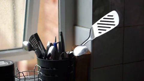 Close-up handheld shot of various spoons in container on window sill 스톡 동영상 120153265