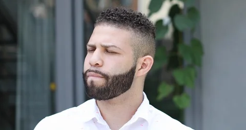 Close-up handheld shot of young man with beard sitting on stairs Stock Footage 119938431