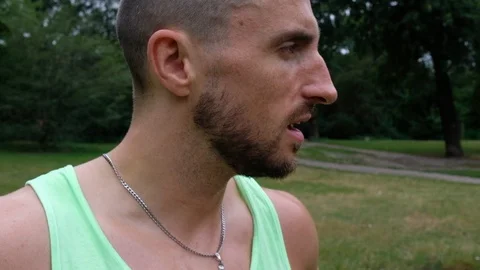 Close-up handheld shot of young man with beard breathing deeply Video stock 120427926