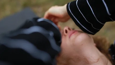 Close-up handheld shot of young woman with curly hair practicing yoga Stock Footage 120426341