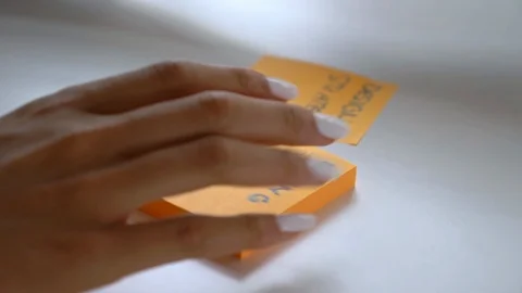 Close-up handheld of woman's hand taking two sticky notes in office Video stock 114871393