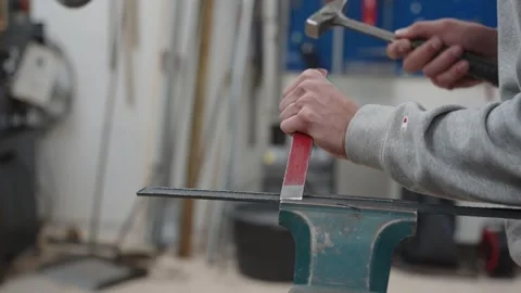 Close-up handheld of young apprentice man hands working with hammer and a Stock Footage 246273217