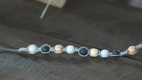 Close-up of a handmade bracelet made of beads on a wooden table Stock Footage 119646772