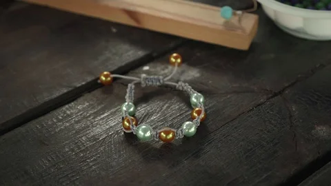 Close-up of a handmade bracelet made of beads on a wooden table Stock Footage 119647445