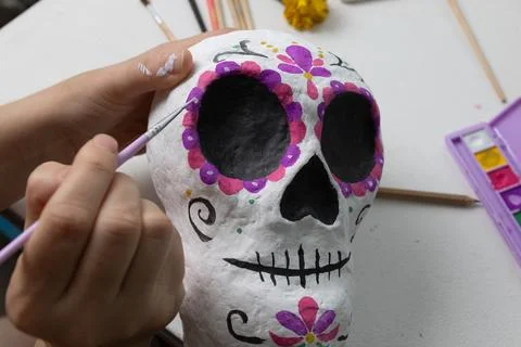Close-up of a handmade ceramic skull being painted for Day of the Dead, showc Stock Photos