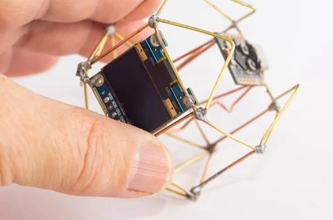 A close-up of a handmade decorative clock held in a hand. Foto stock
