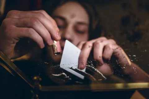 Close-up of the hands of an addicted young man snorting powdered Stock Photos