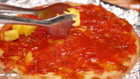 Close up of hands adding healthy ingredients into homemade pizza in kitchen. Vidéo 158669391