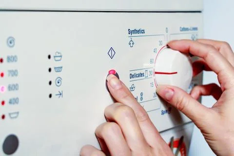 Close up hands adjust settings on washing machine Stock Photos