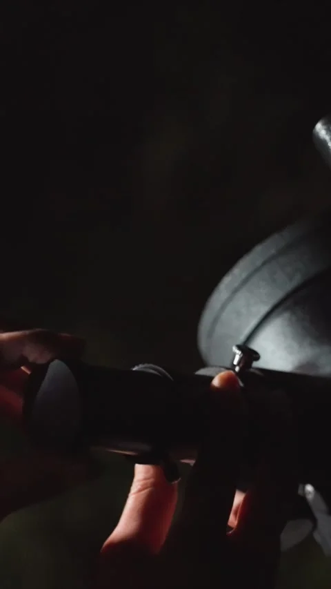 Close up hands adjusting camera lens on tripod in dim low light focus on manual Stock Footage 345545279