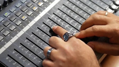 Close-up of hands adjusting levels on a switch board for tv and audio Stock Footage 97149181