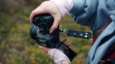 Close-up of hands adjusting mirrorless camera with raindrops outdoors Stock Footage 340109001