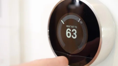 Close-up of hands adjusting a Nest thermostat in smart home. Stock Footage