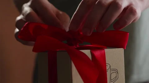 Close up of hands adjusting red ribbon bow on gift box Stock Footage 340139134