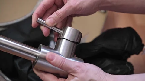 Close-up of hands adjusting a stainless kitchen faucet Stock Footage 304433555