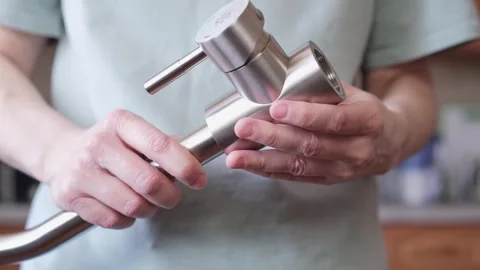 Close-up of hands adjusting a stainless kitchen faucet Stock Footage 304433558
