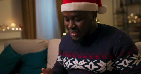 Close-up of the hands of African-looking guy who unpacks Christmas present. He 스톡 동영상 211277665