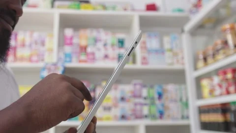 Close Up, Hands of African Pharmacist Using tablet to check Inventory, Medicine Stock Footage 345512009