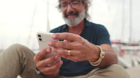 Close-up of the hands of an aged man holding mobile phone, the background is Stock Footage 252503562