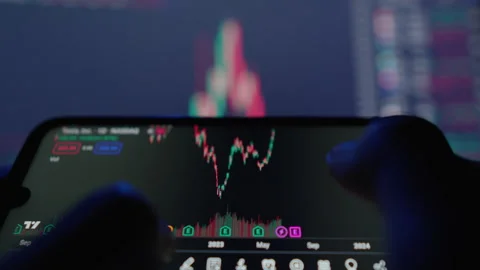 Close up of hands analyzing a digital stock market chart on a smartphone with Stock Footage 341041338