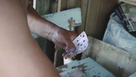 Close-up of the hands and chest of an old man with bare torso, who playing cards Stockbeeldmateriaal 134394176
