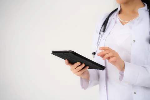 Close up of the hands and electronic tablet of a young girl doctor Foto stock