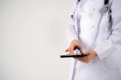 Close up of the hands and electronic tablet of a young girl doctor Stock Photos