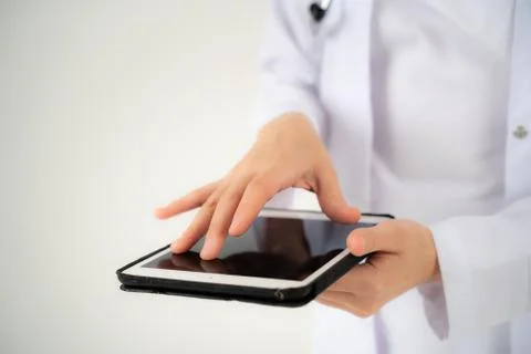 Close up of the hands and electronic tablet of a young girl doctor Stock Photos