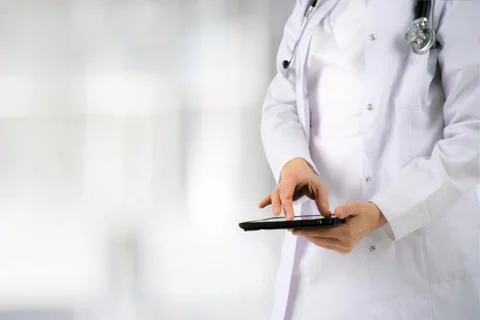 Close up of the hands and electronic tablet of a young girl doctor Stock Photos