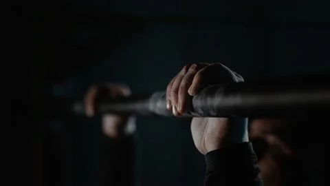 Close-up hands and head a man pulling up on the horizontal bar in sport room Stock Footage 194045031