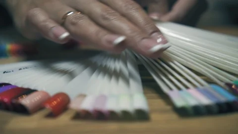 Close up hands and nail polish samples. Girl hand with multicolored summer Stock Footage 93985109