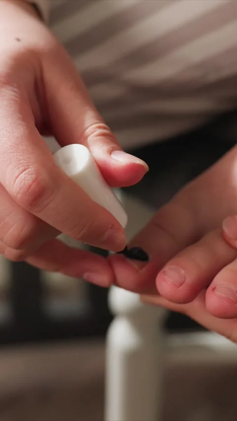 Close up of hands applying black nail polish with precision featuring Stock Footage 346794925