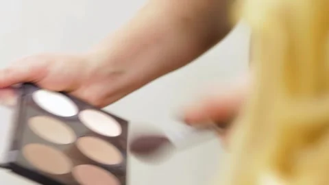 Close-up of hands applying rouge at a vibrant hair salon Stock Footage 311932112