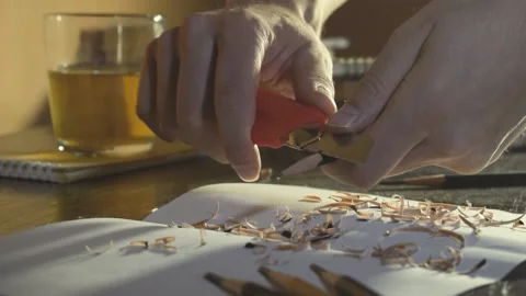 Close up Hands are sharpening a simple pencil with a knife. Stockbeeldmateriaal 160618280