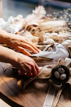 Close-up of hands arranging a dried flower bouquet in warm natural light Stock Photos