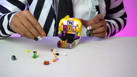 Close-up hands assembling LEGO bricks on a table, horizontal framing Vidéo 329584875
