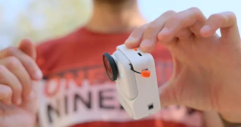 Close-up of hands attaching a magnetic accessory case to a compact action Stock Footage 345021984