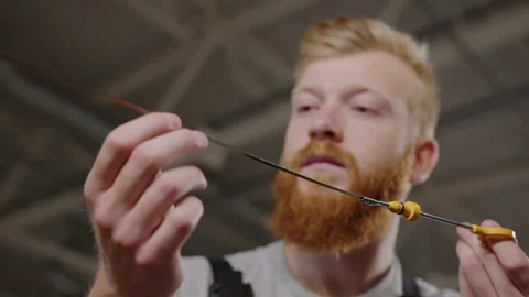 Close-up of the hands of an auto mechanic who looks at the engine oil dipstick Stock Footage 253173980