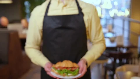 Close up of a hands of barista taking a plate with croissants Stock Footage 150963882