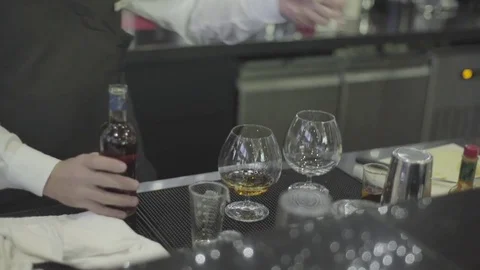 Close-up, hands the bartender poured and served cognacat the bar Stock-Footage 83539403