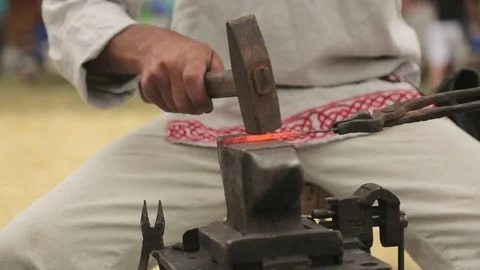 Close-up of the hands of blacksmith and his pupil with the hammers striking the Stock Footage 82661178